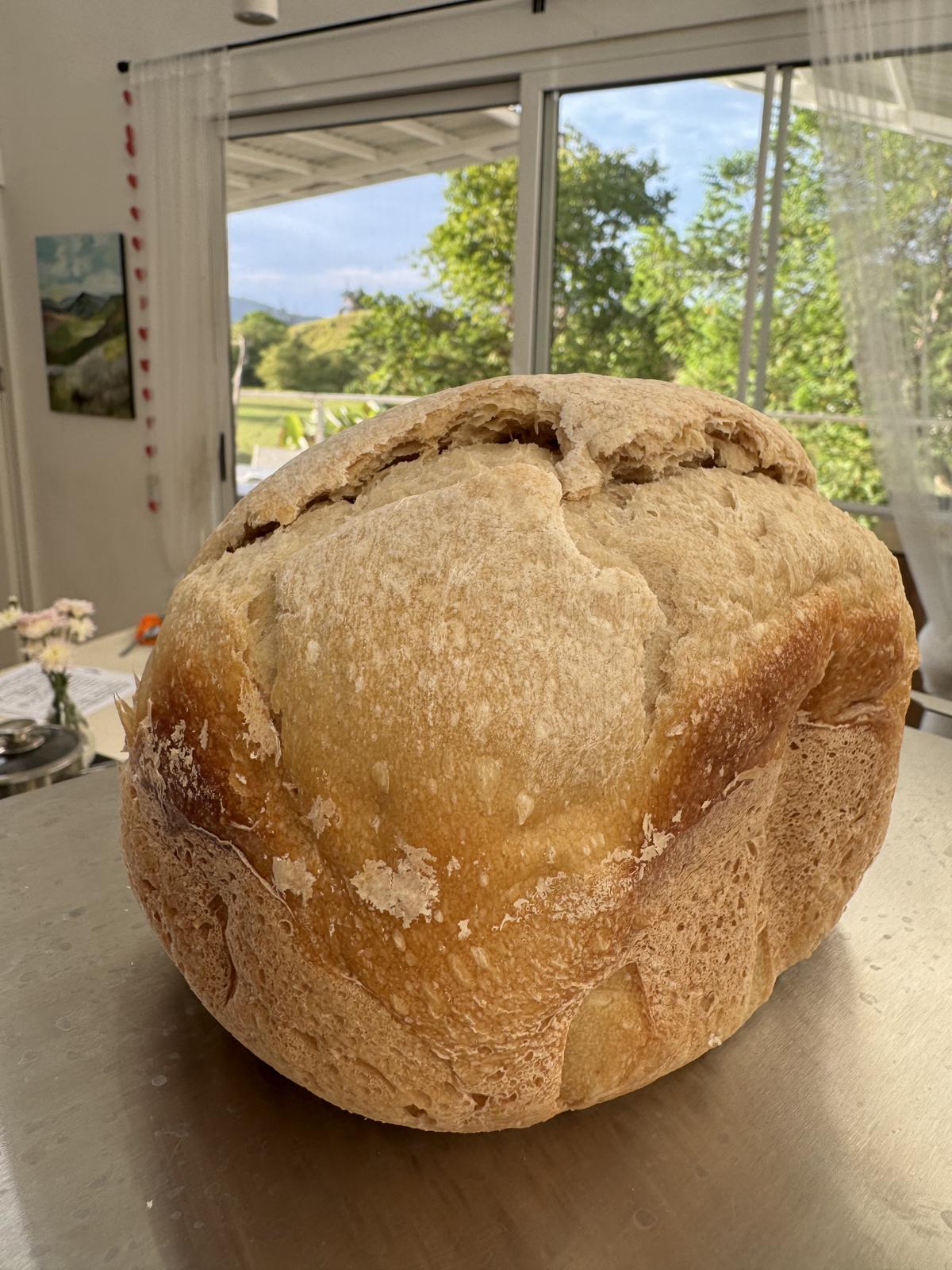 A loaf of fresh bread on the kitchen counter, with the hills visible through the window