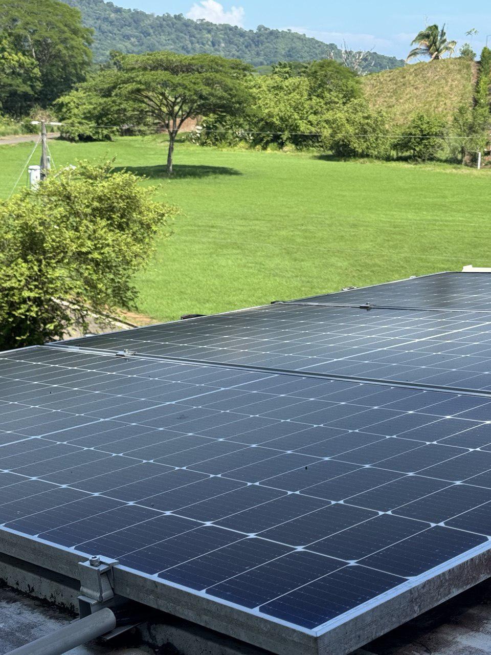 Rooftop solar panels overlooking the green field and hills beyond